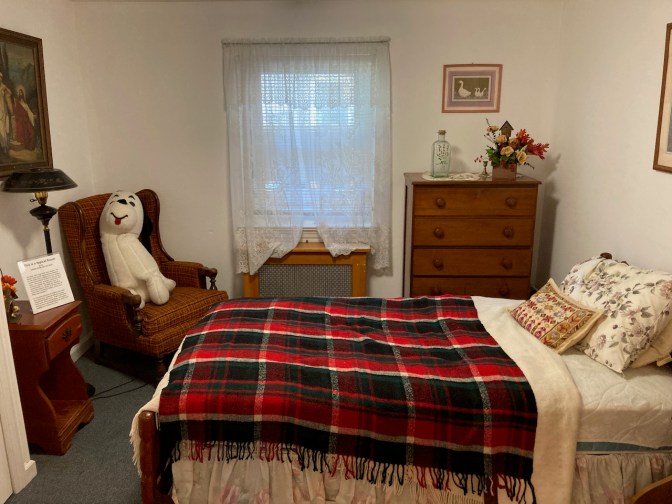 Small room, with bed, dresser, and chair.
