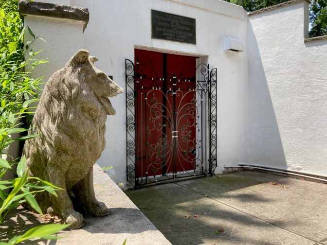 Entrance to Danish burial mound, with dog in foreground.