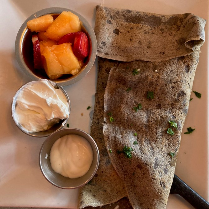 Gallett on plate, with cut fruit, cream, and sour cream.
