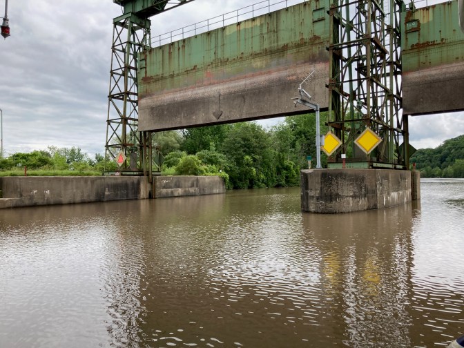 Large steel dam, with both gates open.