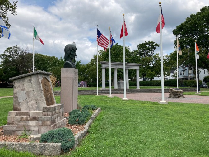 Park square, with flags, statues, and monuments.