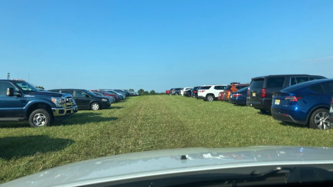 View of grassy field used as parking lot.