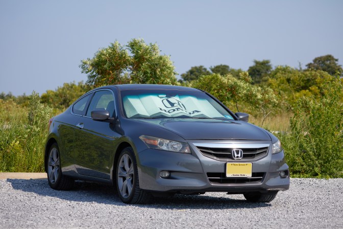 2012 Honda Accord parked in gravel lot.