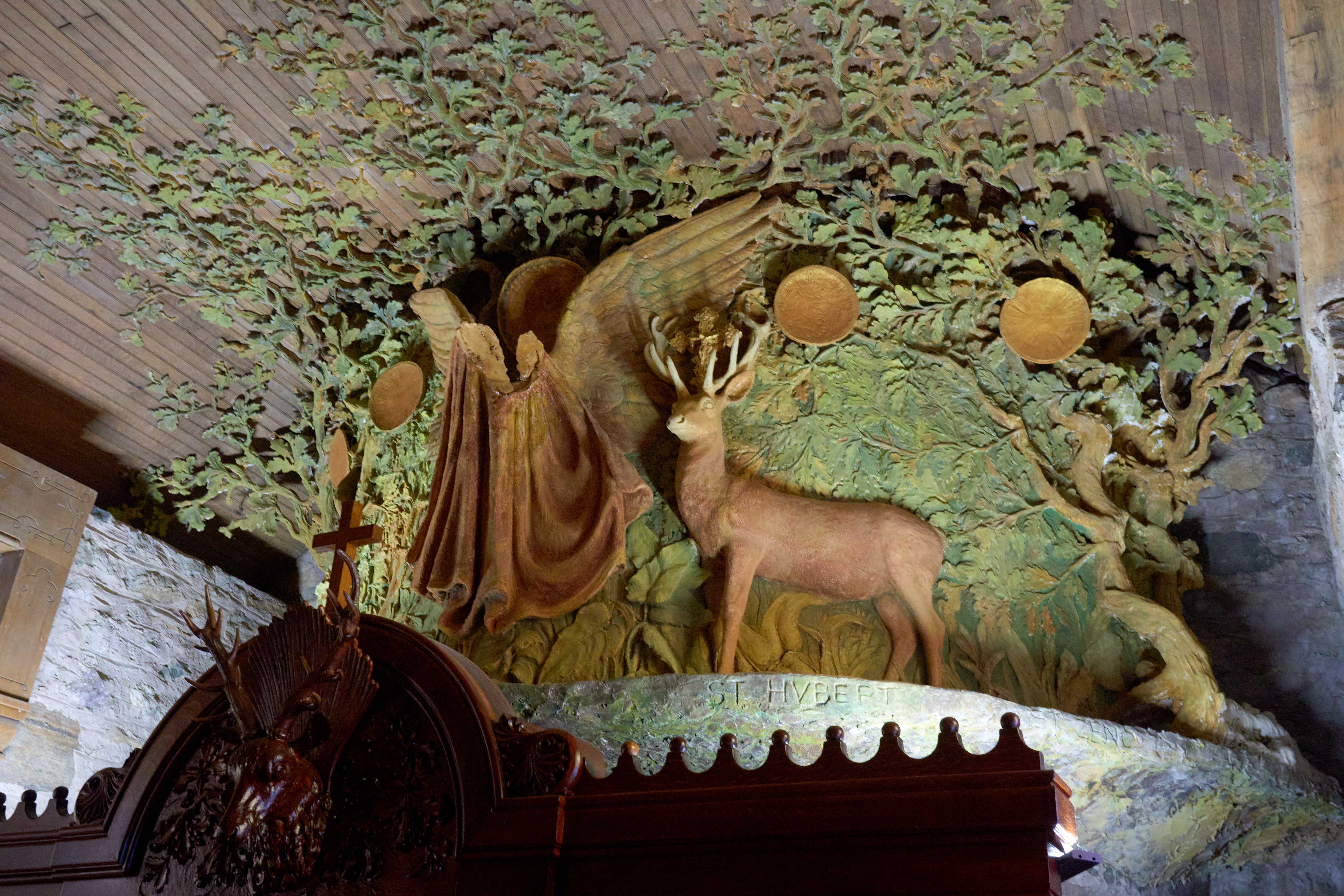 Carved woodland scene on top of confessional.