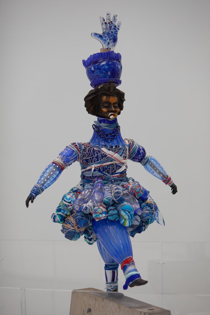 Glass sculpture of man in costume.