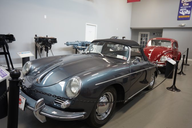 1960 Porsche 356B in gray, with red Beetle behind it.