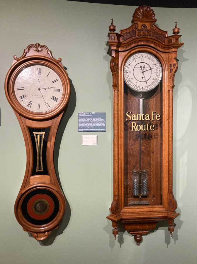 Two railway clocks on wall, one of which says SANTA FE ROUTE.
