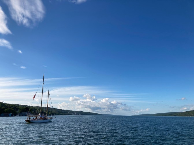 View of Seneca Lake, with sailboat on the lake, heading north.
