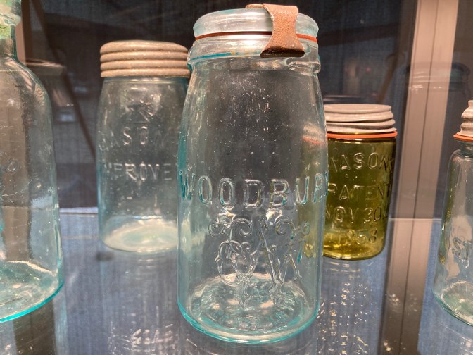 Glass jar with word WOODBURY on side of it.