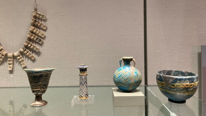 Egyptian glass items, including small vases and a necklace.