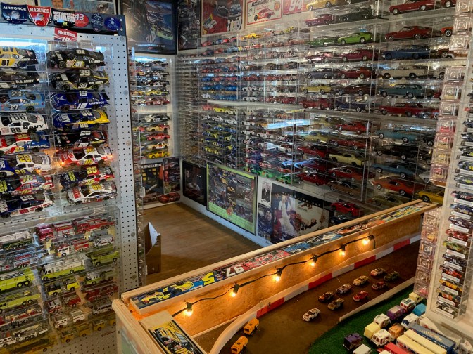 Toy die cast cars in racks on walls.