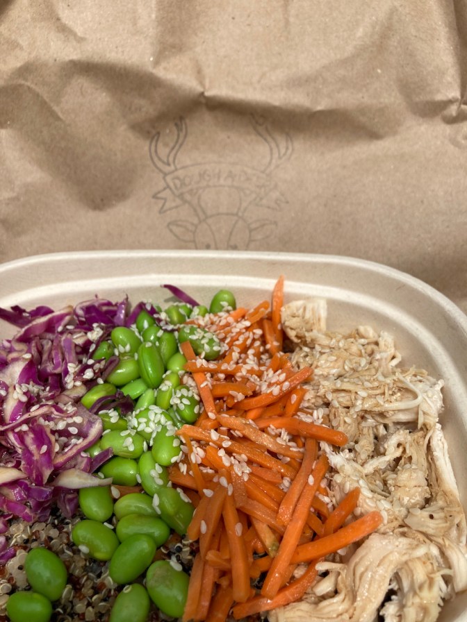 Bowl with cabbage, edamame, carrots, chicken, and rice.