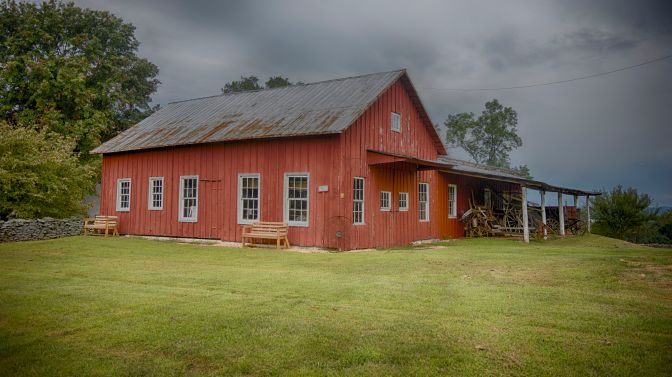 Blacksmith shop, in red wood, in field.