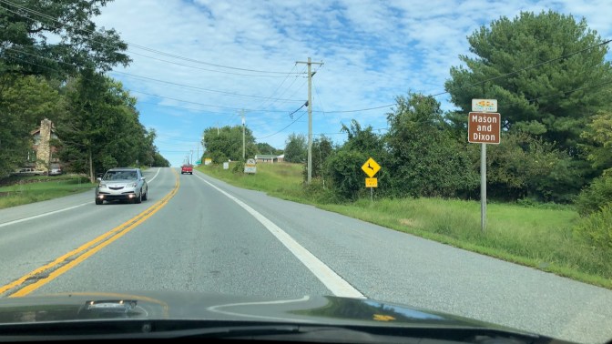 Mason and Dixon line marker along country road.
