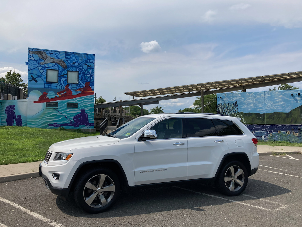 2014 Jeep Grand Cherokee parked in front of Raritan River Ways mural in public park.