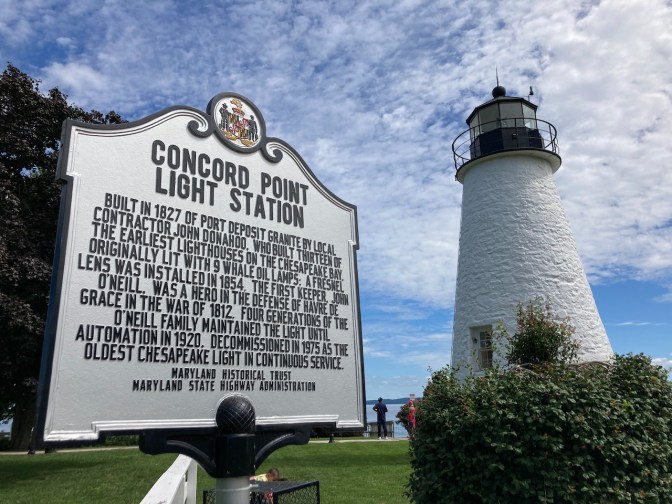 Sign in front of Lighthouse telling its history, with Concord Point Lighthouse in background.