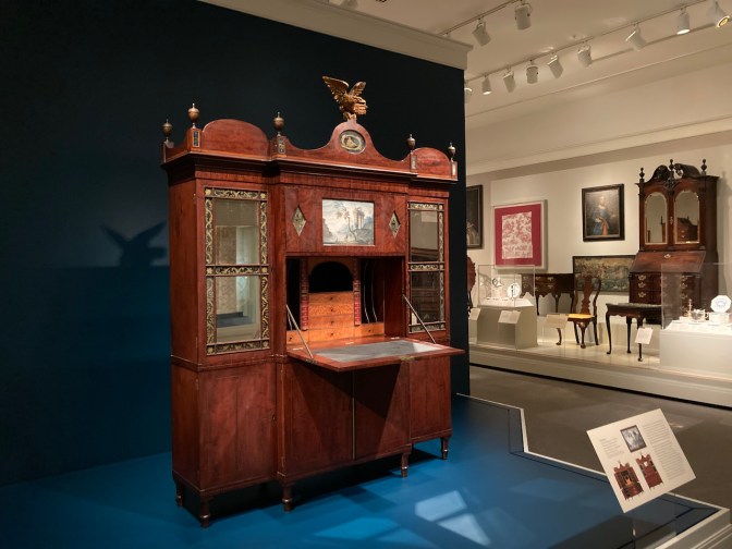 Large wooden secretary in museum gallery of furniture.
