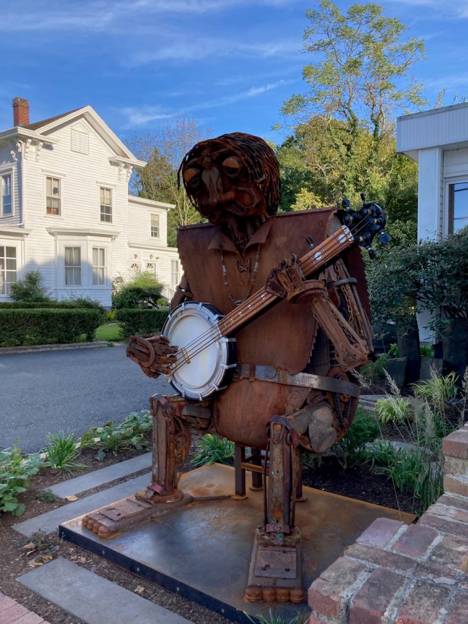 Metal sculpture of banjo player. 