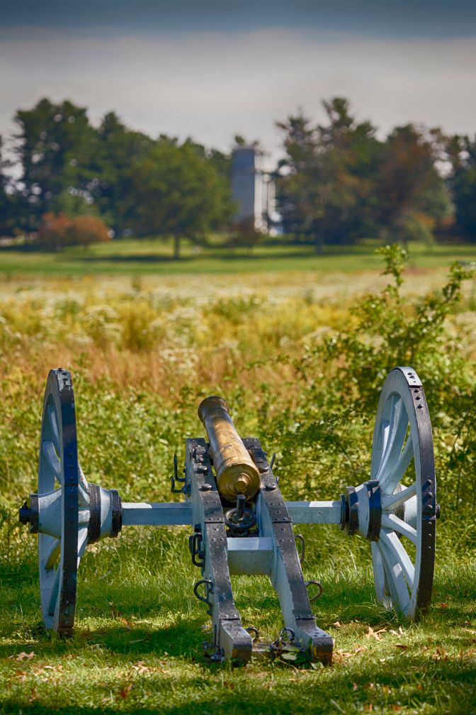 Canon in foreground, with National Memorial Arch in background. 