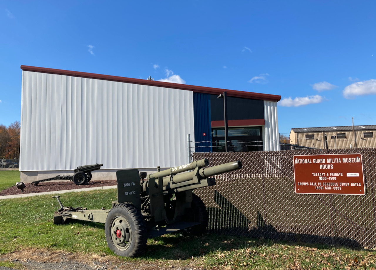National Guard Militia Museum with two towed artillery pieces in front of the entrance. 