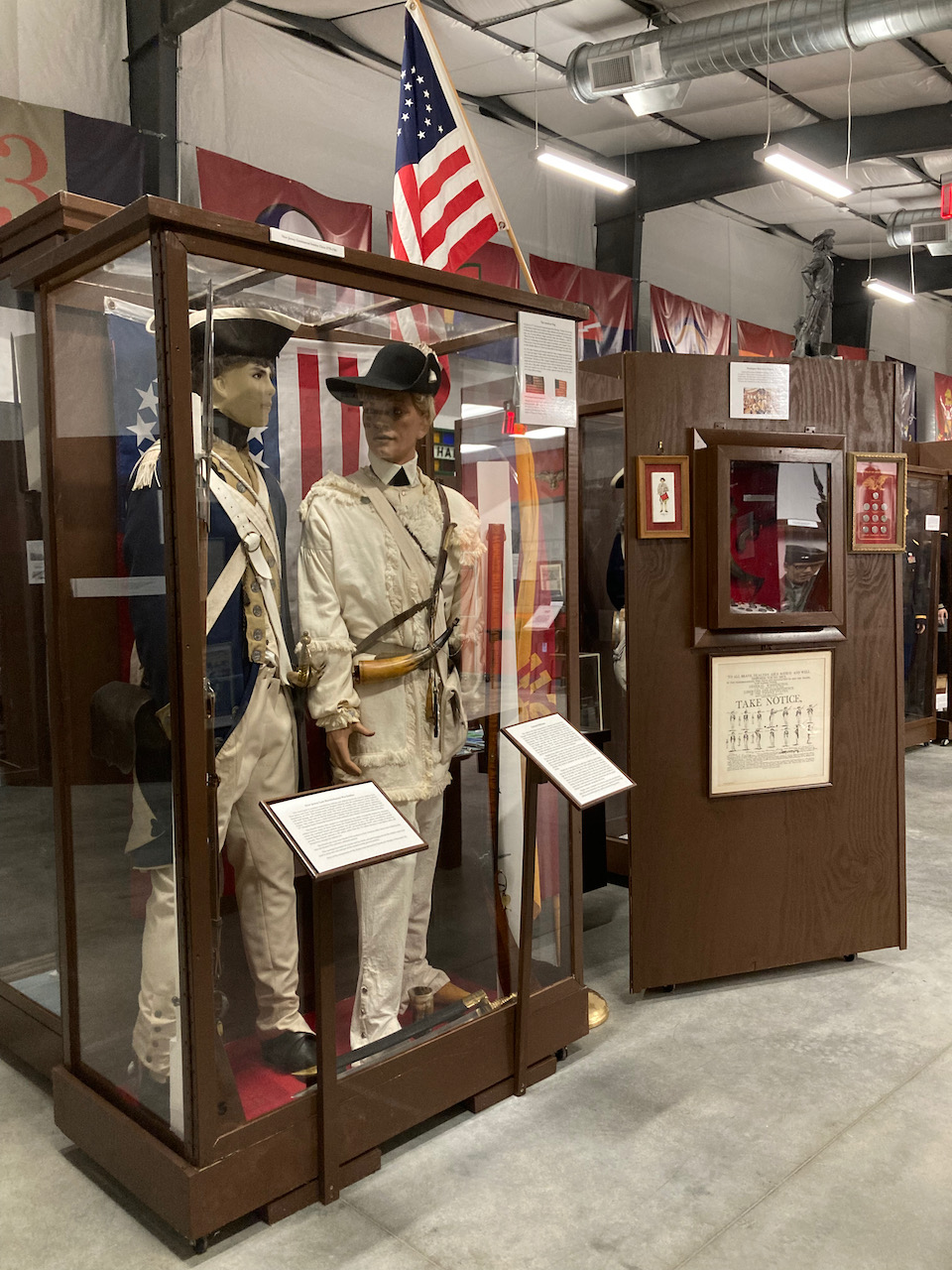 Two mannequins dressed in American Revolutionary War uniforms, in display case. 