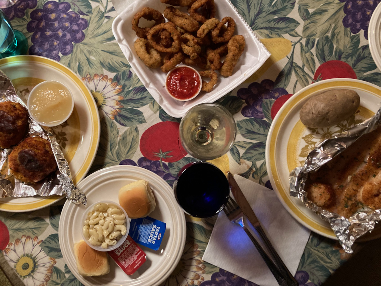 Platters with crab cakes, fish combo, calamari, on table.