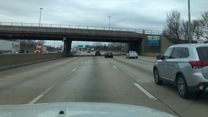 Interstate 90, with overpass approaching and roadside sign that says WELCOME TO ILLINOIS
