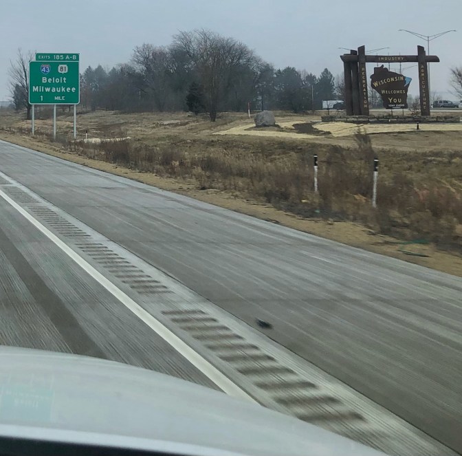 I-90 highway, with sign on side of road that says WISCONSIN WELCOMES YOU!