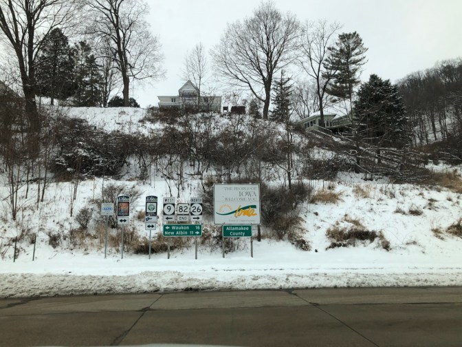 Intersection, with sign that says THE PEOPLE OF IOWA WELCOME YOU.