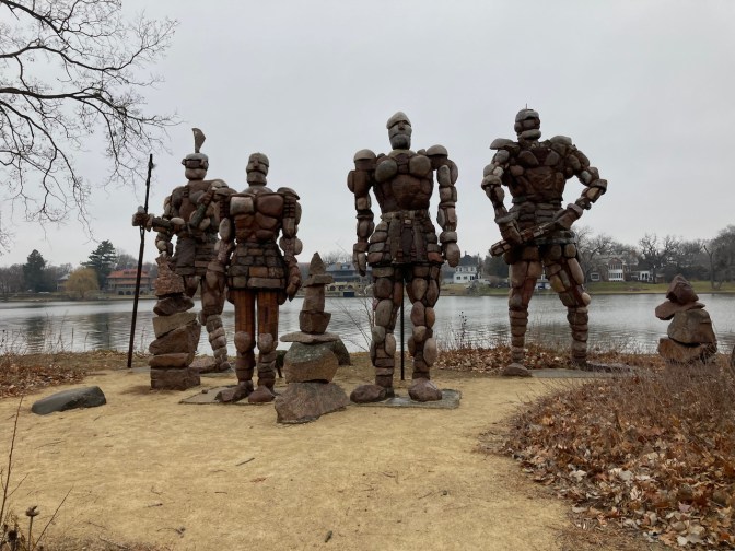 Four sculptures of warriors, constructed from rocks.