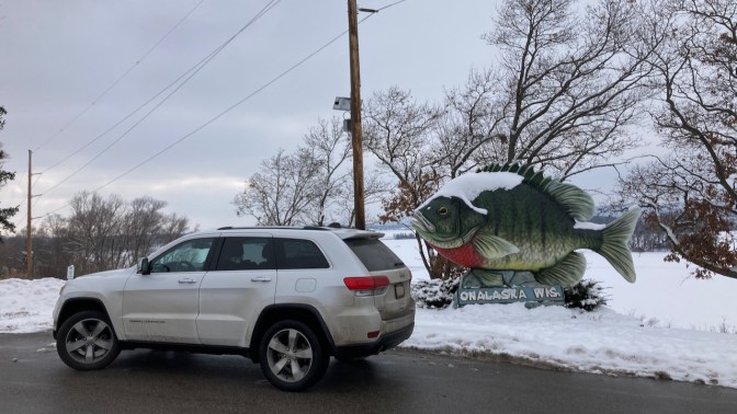 2014 Jeep Grand Cherokee parked beside sunfish statue.