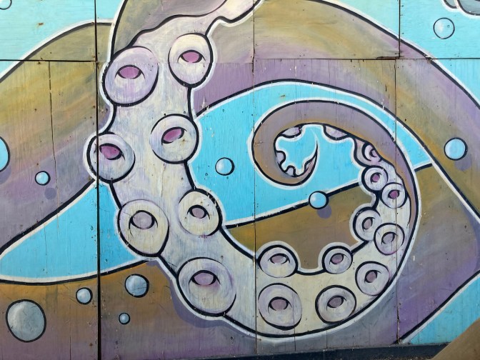 Mural of octopus tentacle on wall.