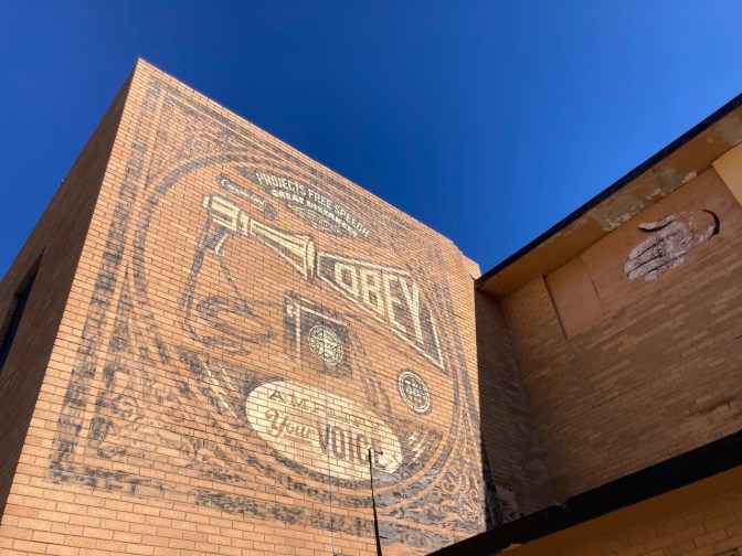 Megaphone amplifier ad painted on side of brick buildling.