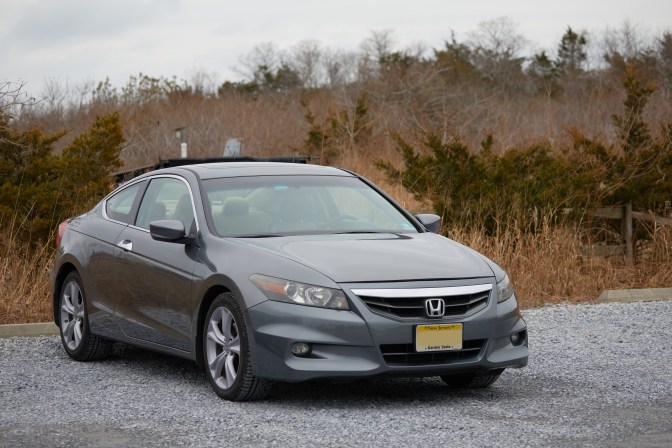 2012 Honda Accord parked in gravel lot.