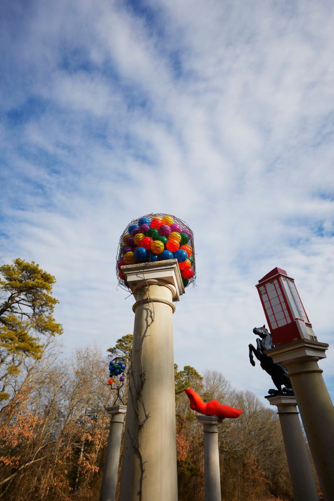 View upward of works of art atop columns.