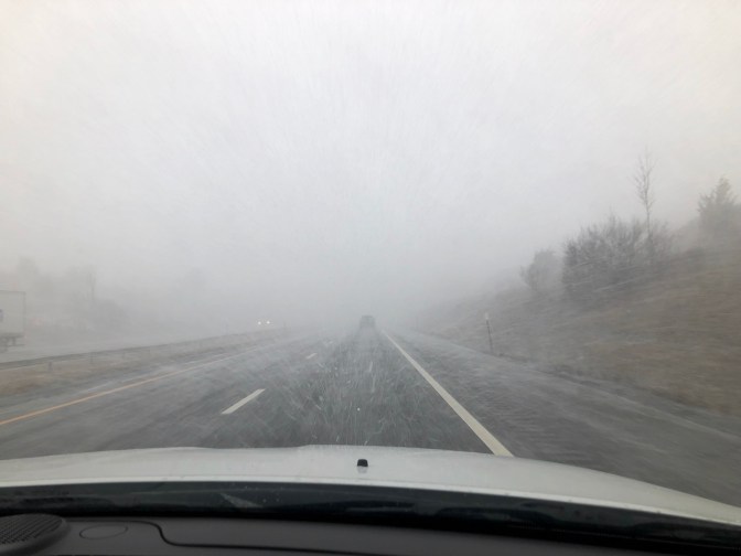 View of snow-covered road with limited visibility.