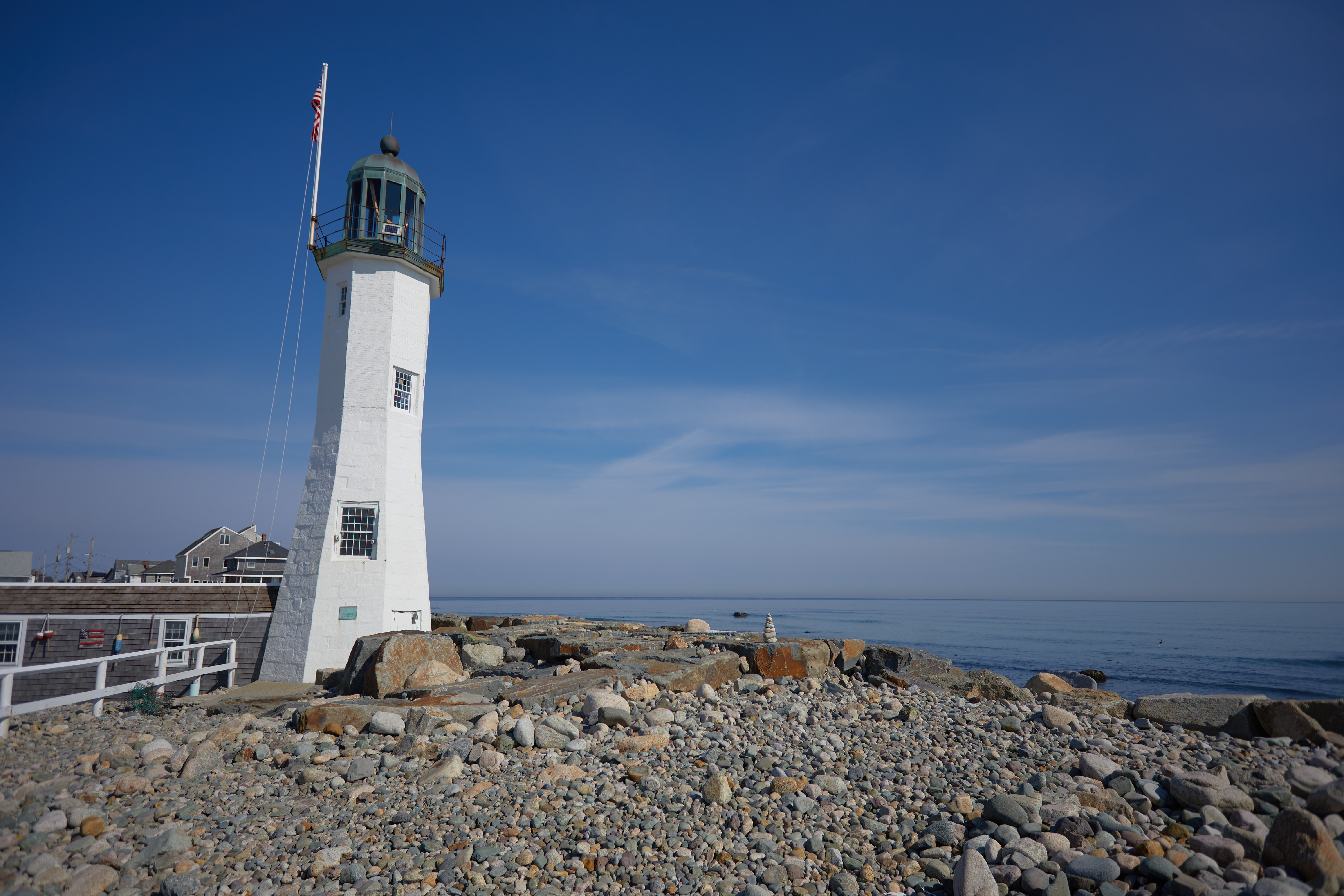 Scituate Lighthouse on rocky coast.