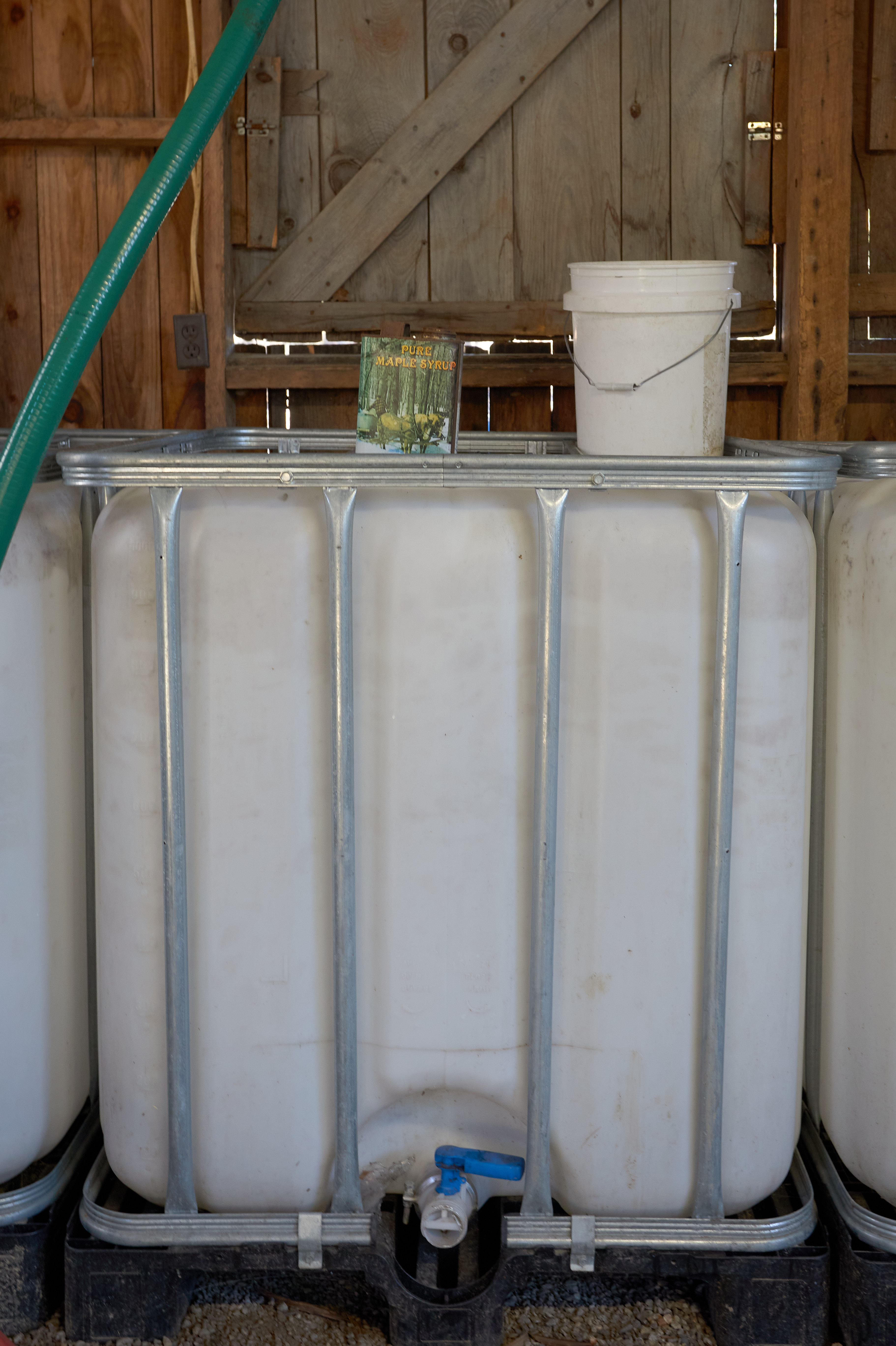 Large holding tank, with smaller half-gallon tin container on top.
