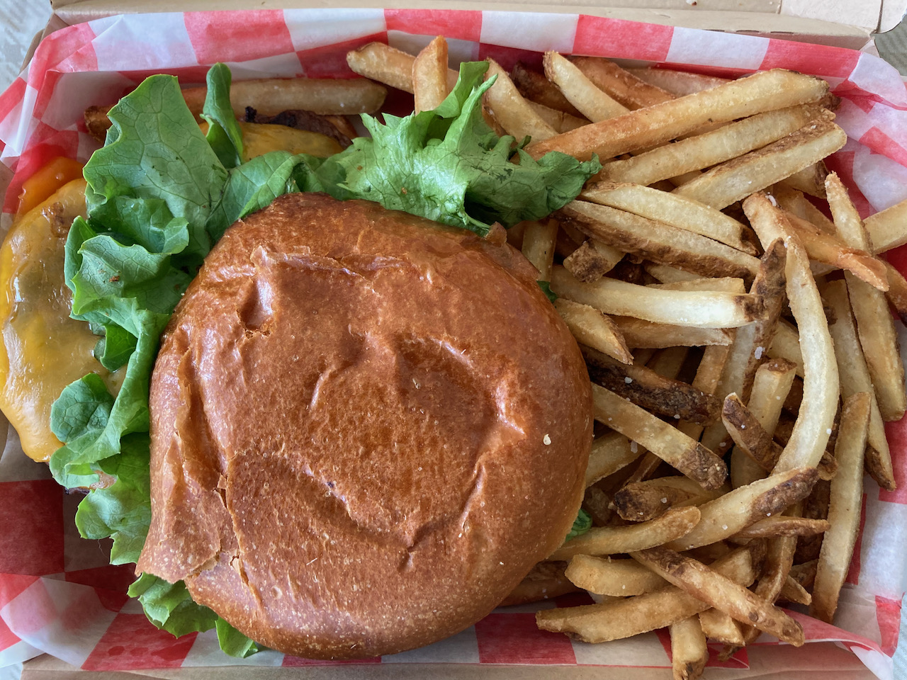 Cheeseburger and fries in basket.