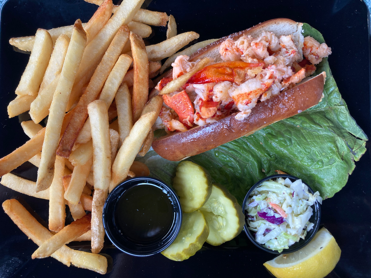 French fries and lobster roll on plate.