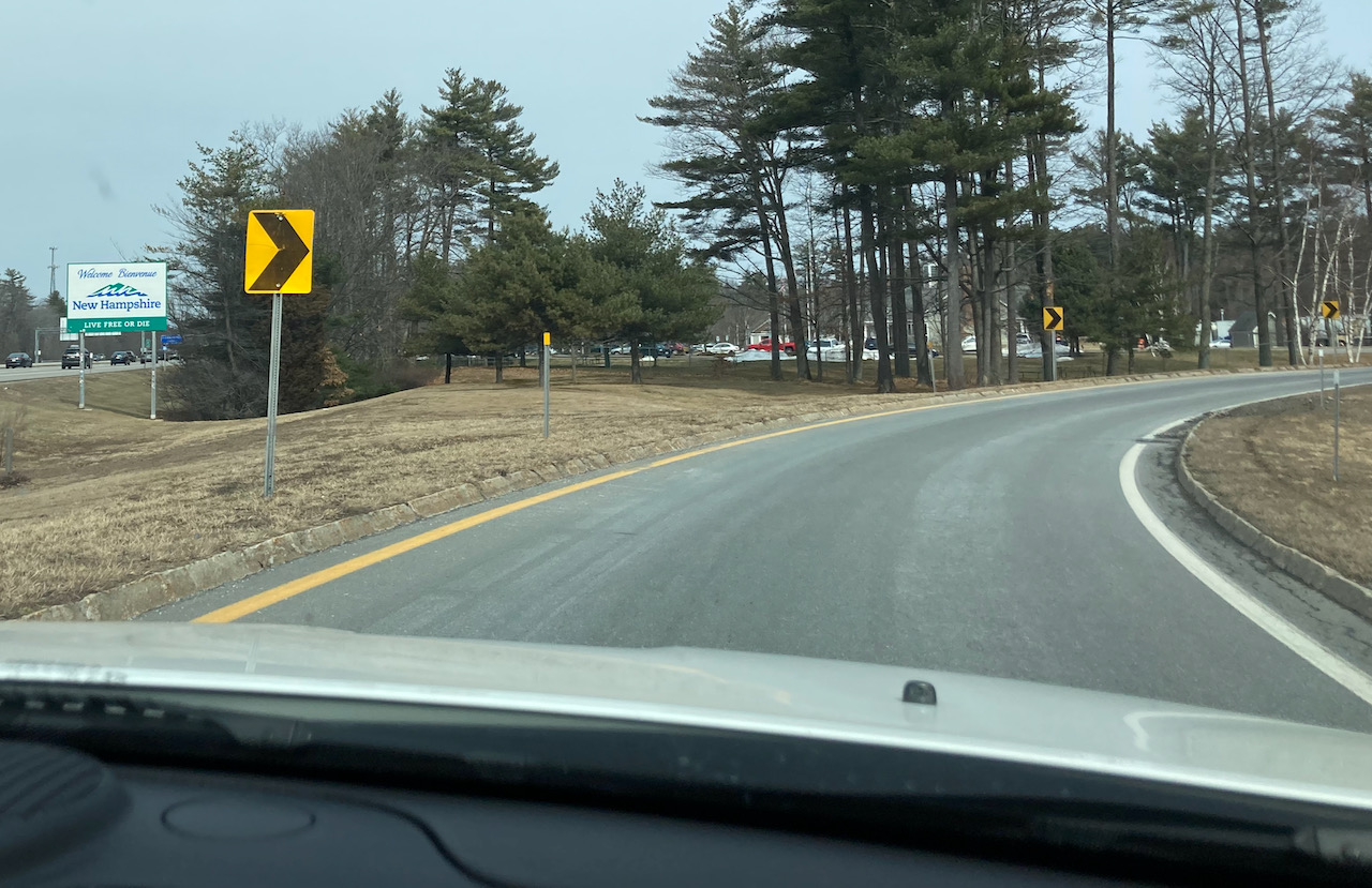 Road with sign on left for New Hampshire.