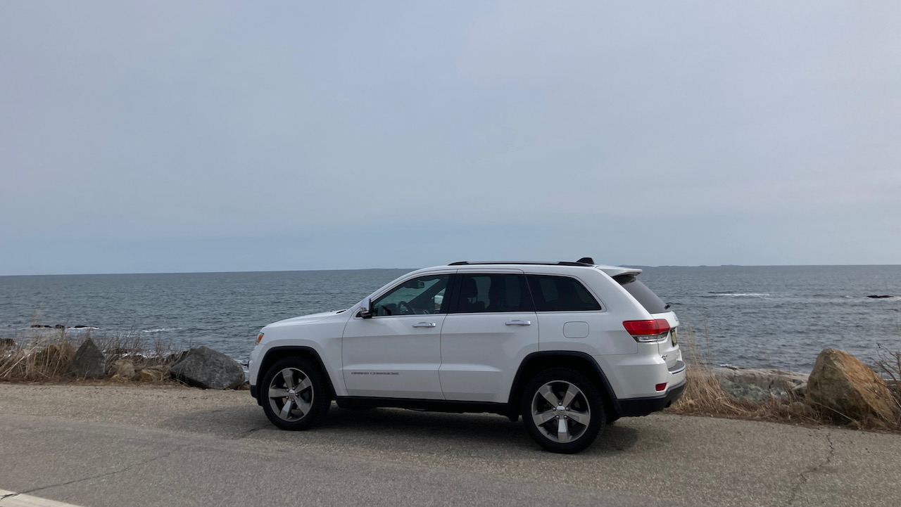 2014 Jeep Grand Cherokee parked in front of ocean.