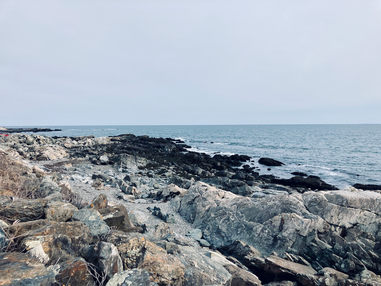 Rocky beach beside ocean.
