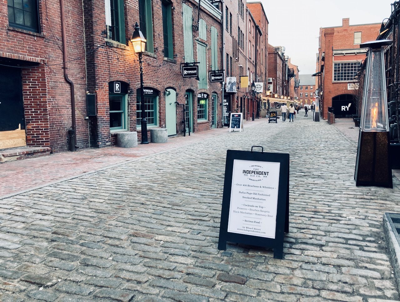 Alleyway in Old Port section of Portland, with brick buildings on both sides, and a cobblestone street.