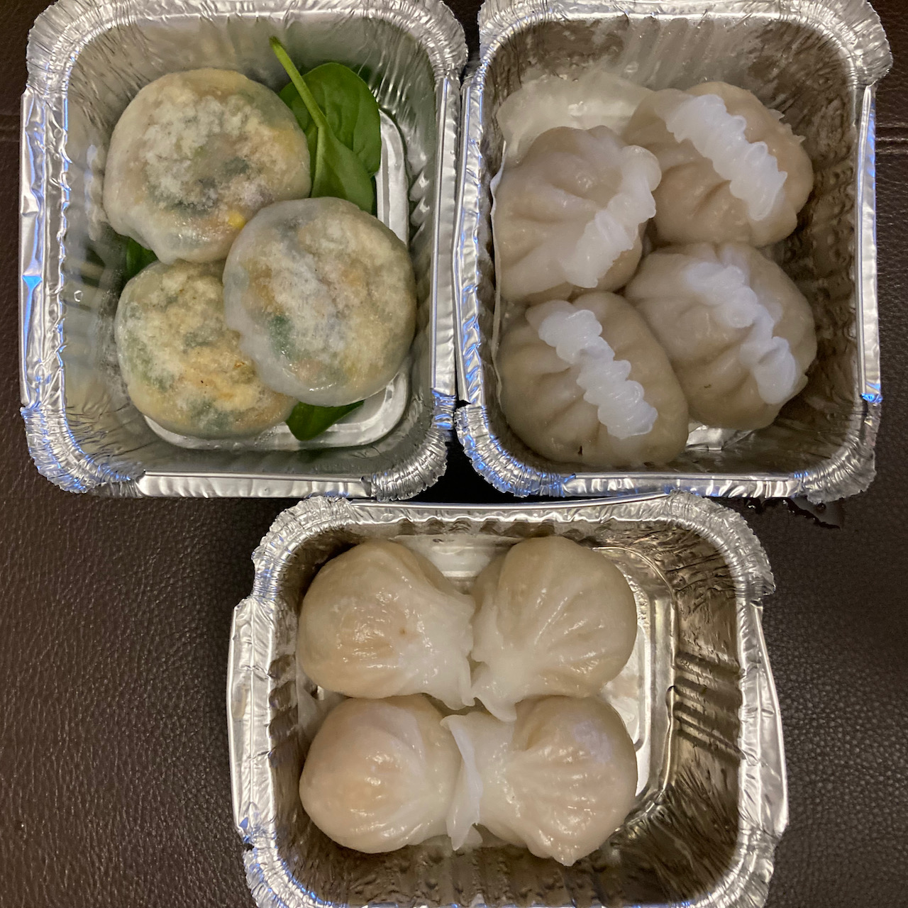 Dumplings in three aluminum containers.