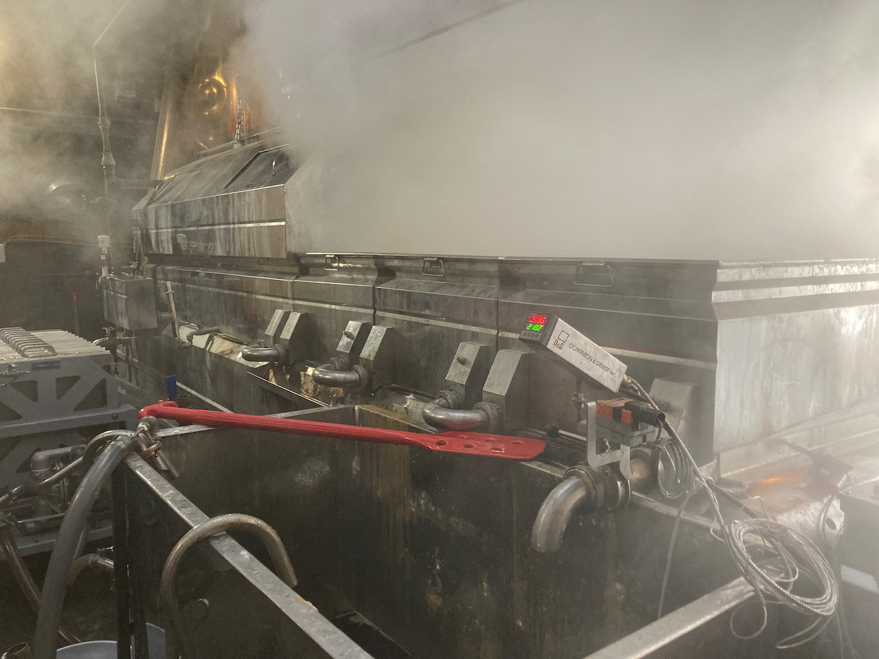 Maple syrup evaporator in operation, with steam billowing out from the top.