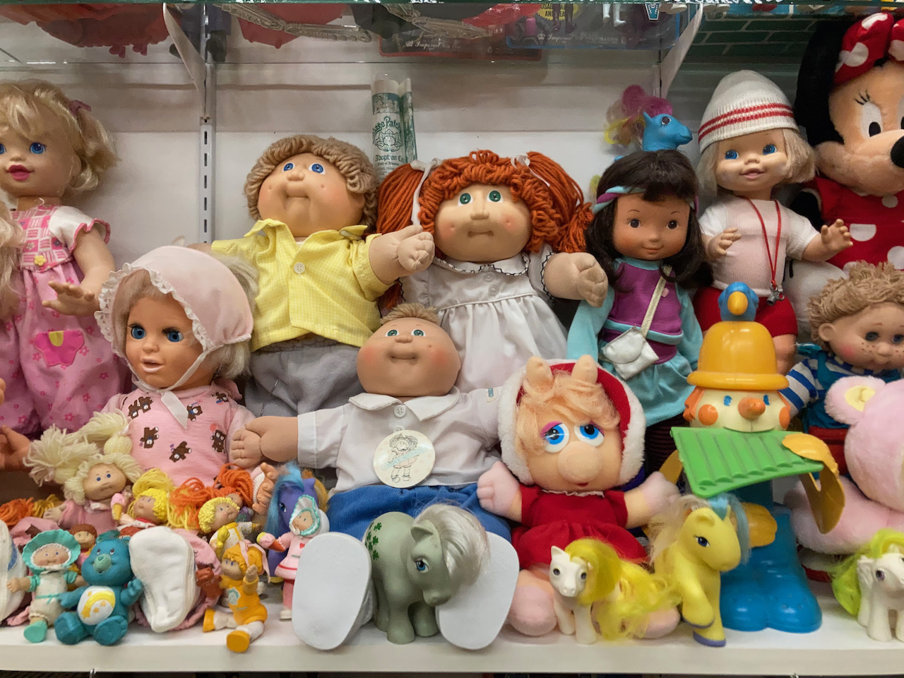 Collection of stuffed animals, including Cabbage Patch Dolls.