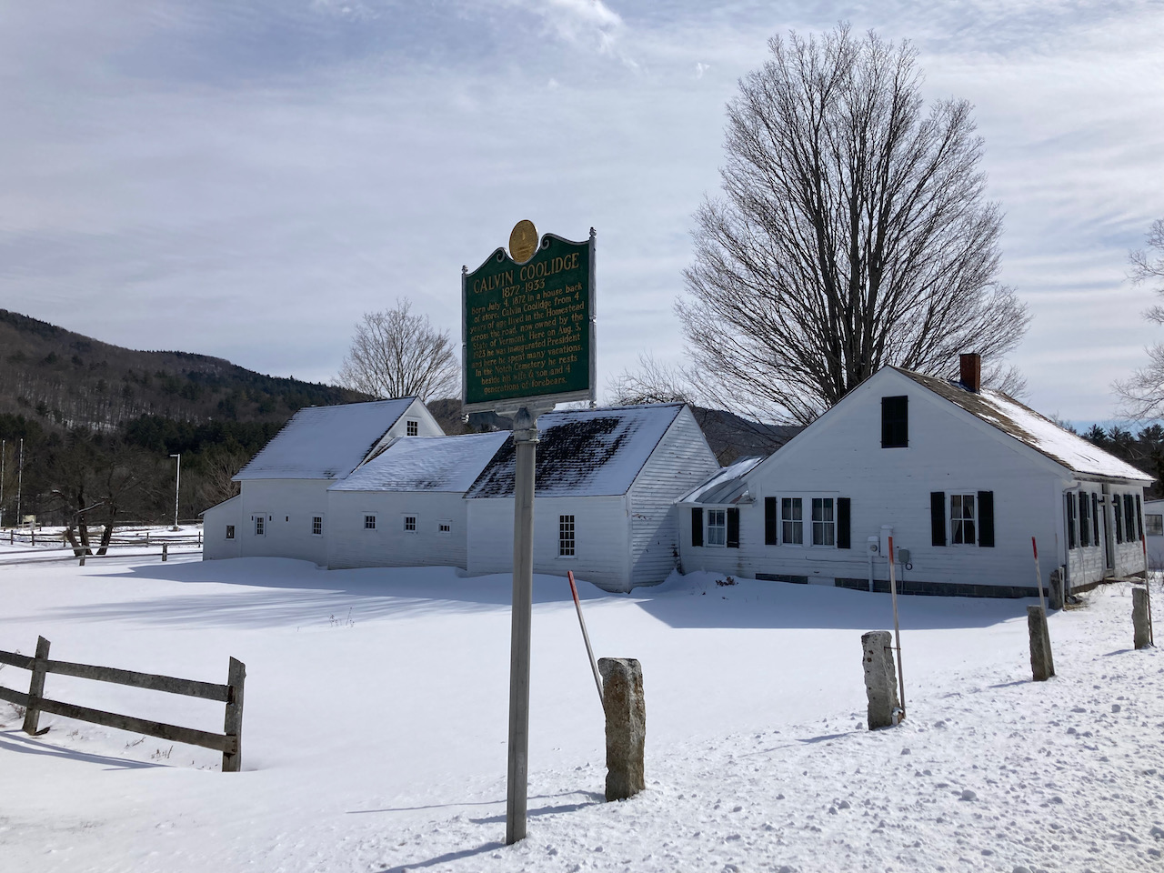 White one-story house with sign in front that says CALVIN COOLIDGE 1872-1933.