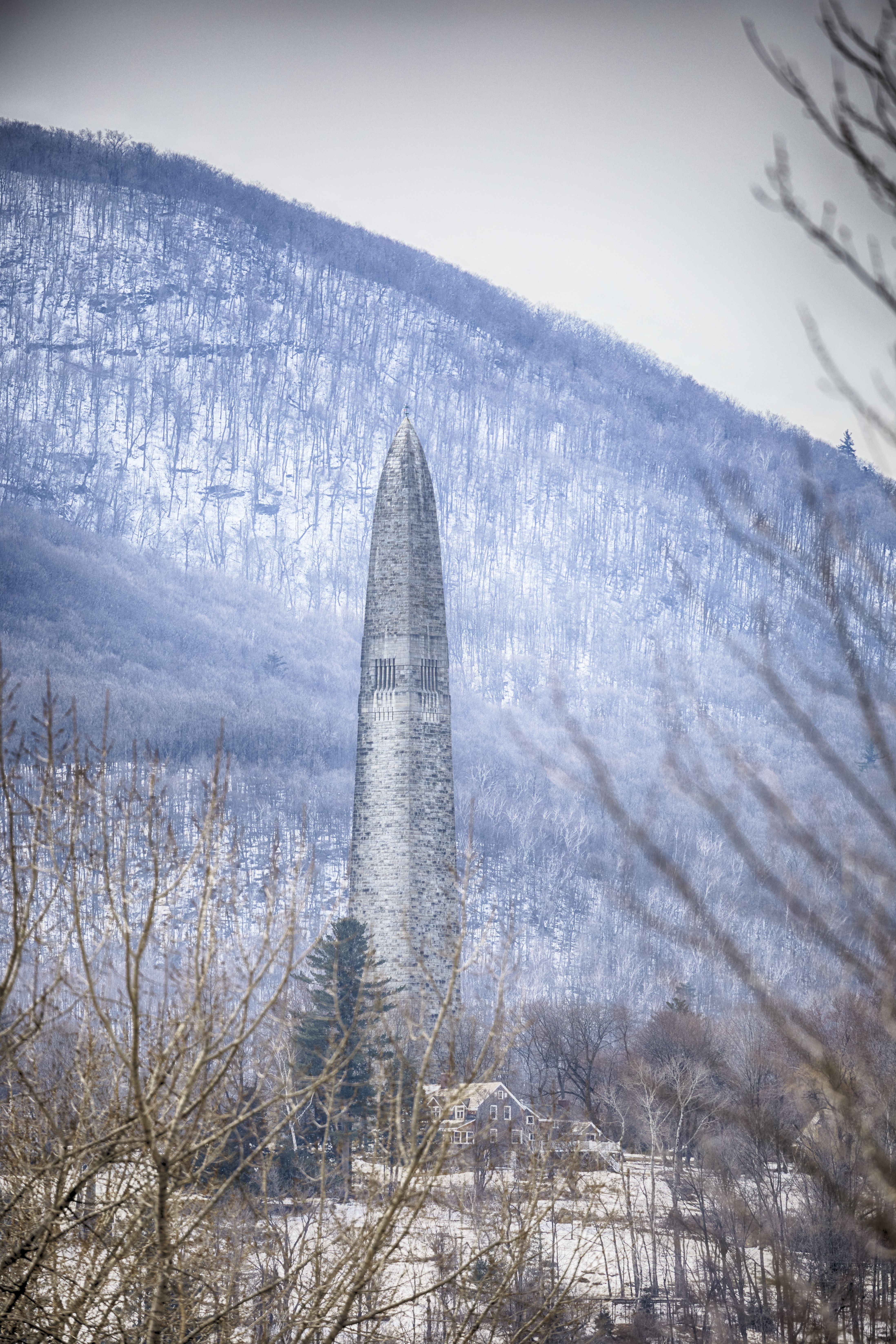 Stone obelisk in distance, with hillside behind it.