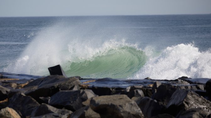 Wave crashing into rocks.